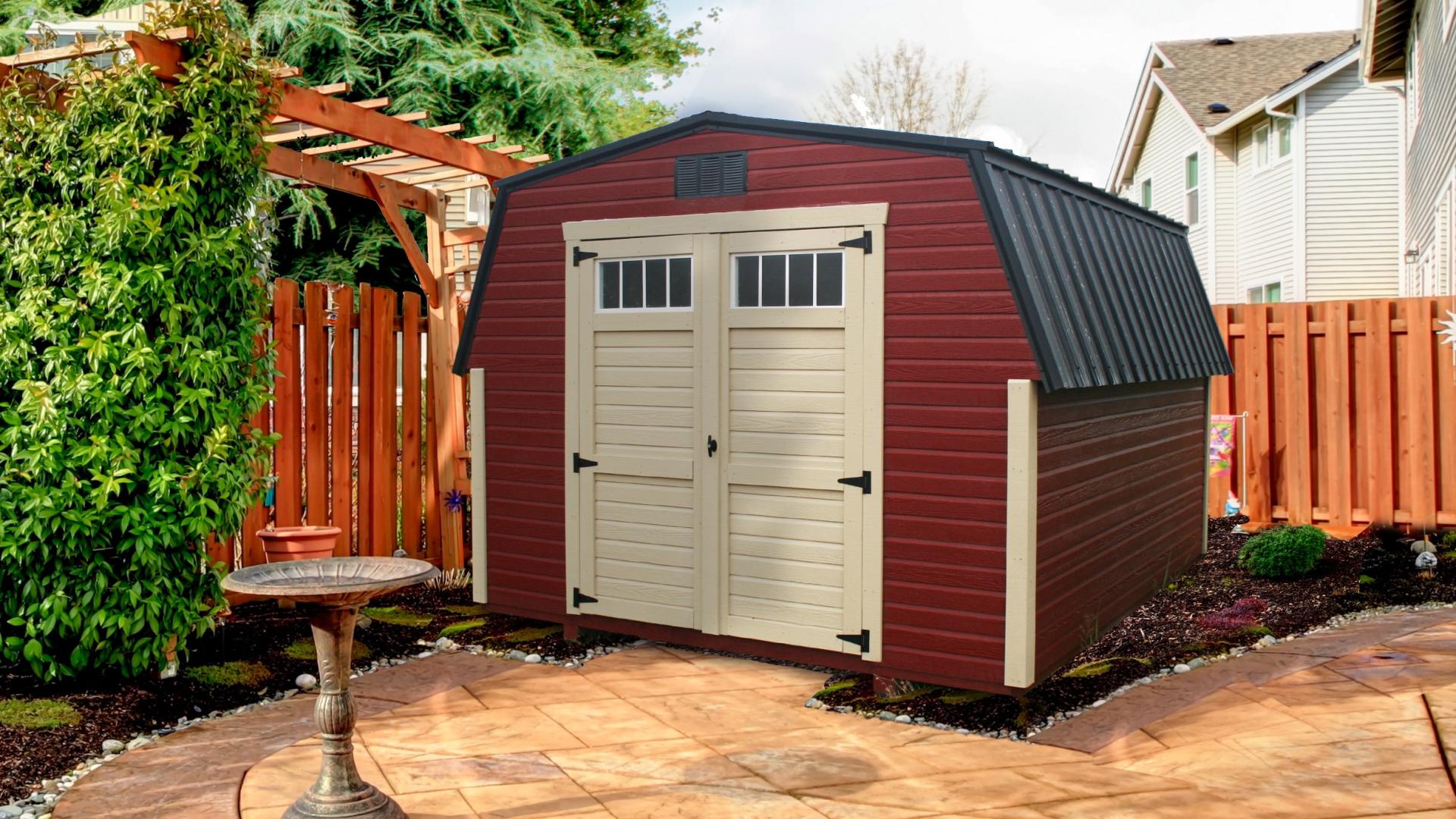 Red mini barn with white trim and black metal roof