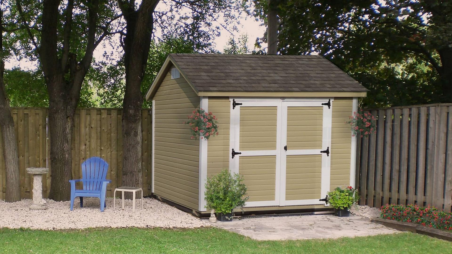 Tan garden shed with white trim in a residential area