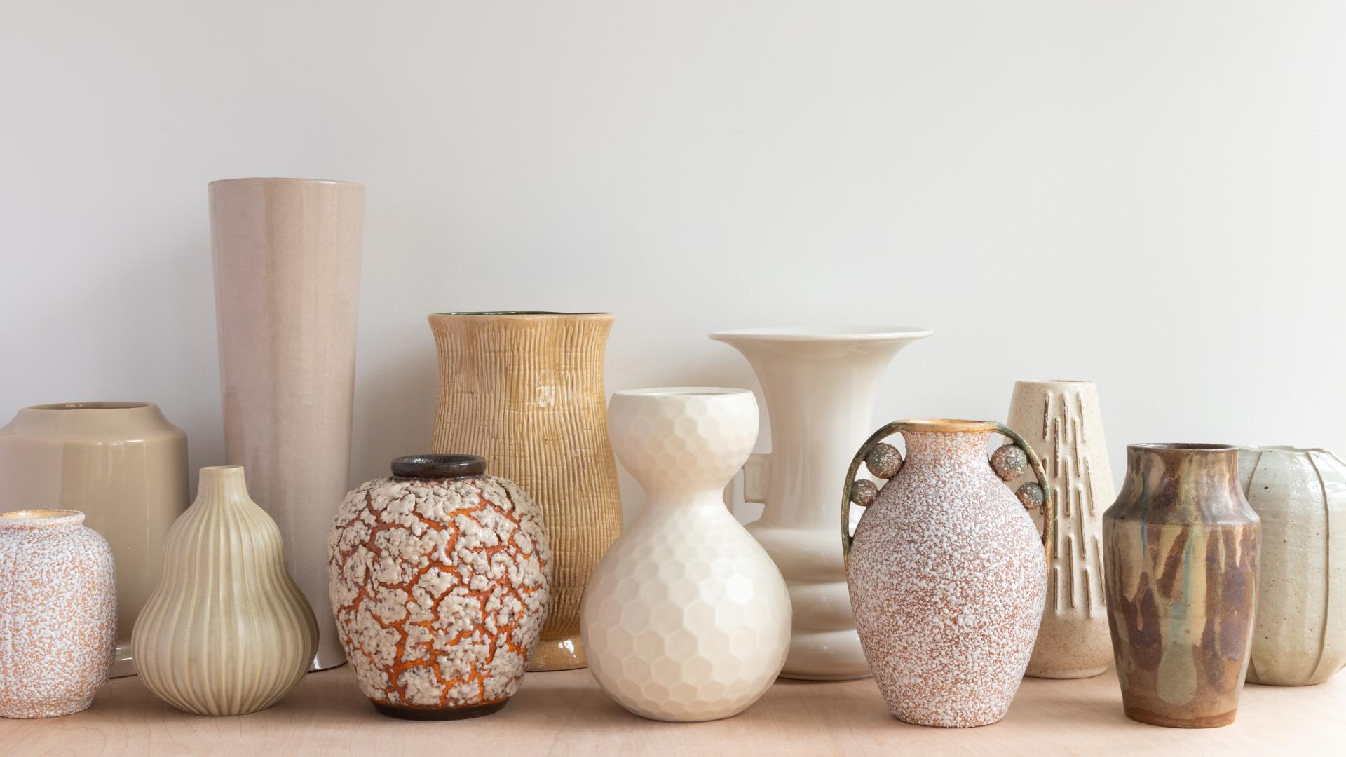 Photo of 12 earth-colored light ceramic vases of different designs.