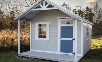 Light gray Signature Hunter Cabin with white trim and a blue door.